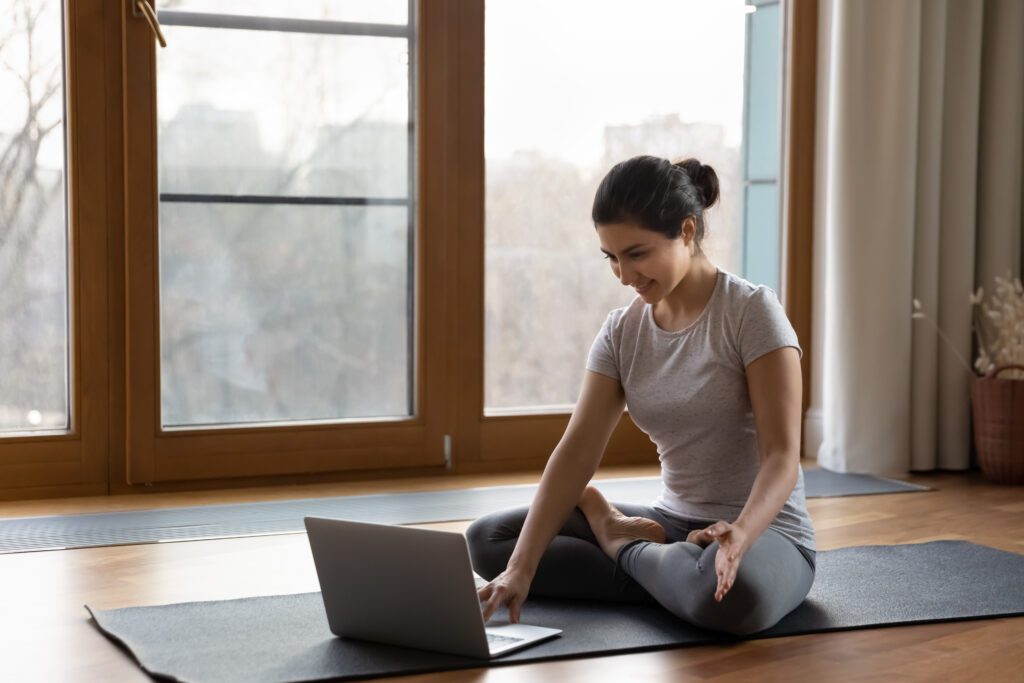 A woman sitting on the floor with her laptop