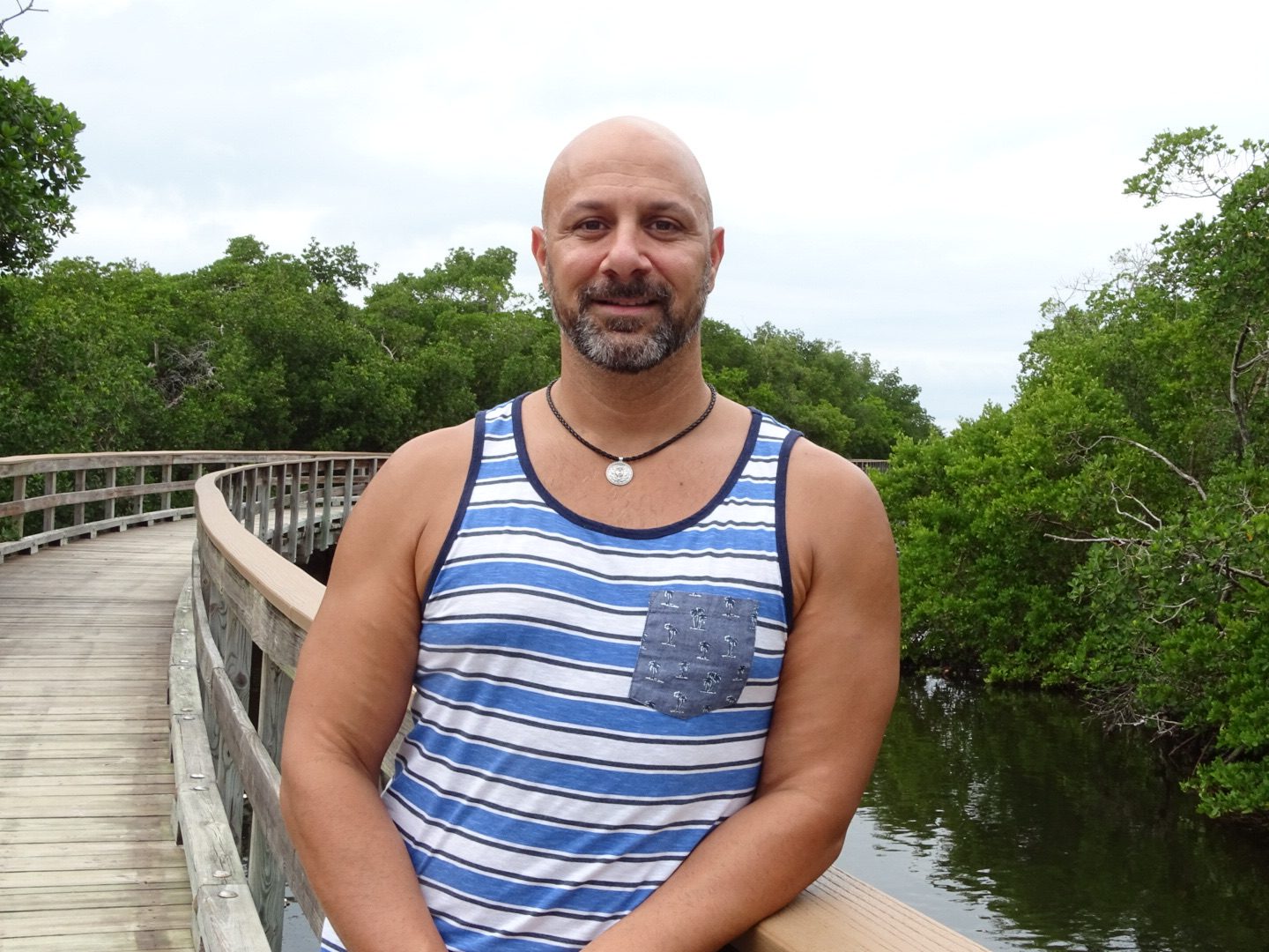 67c083b0b7588_Paul A man in striped shirt standing on bridge over water.